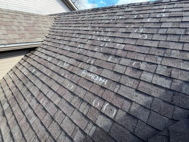 Roof inspection, showing storm damage to asphalt shingles in Louisville, KY