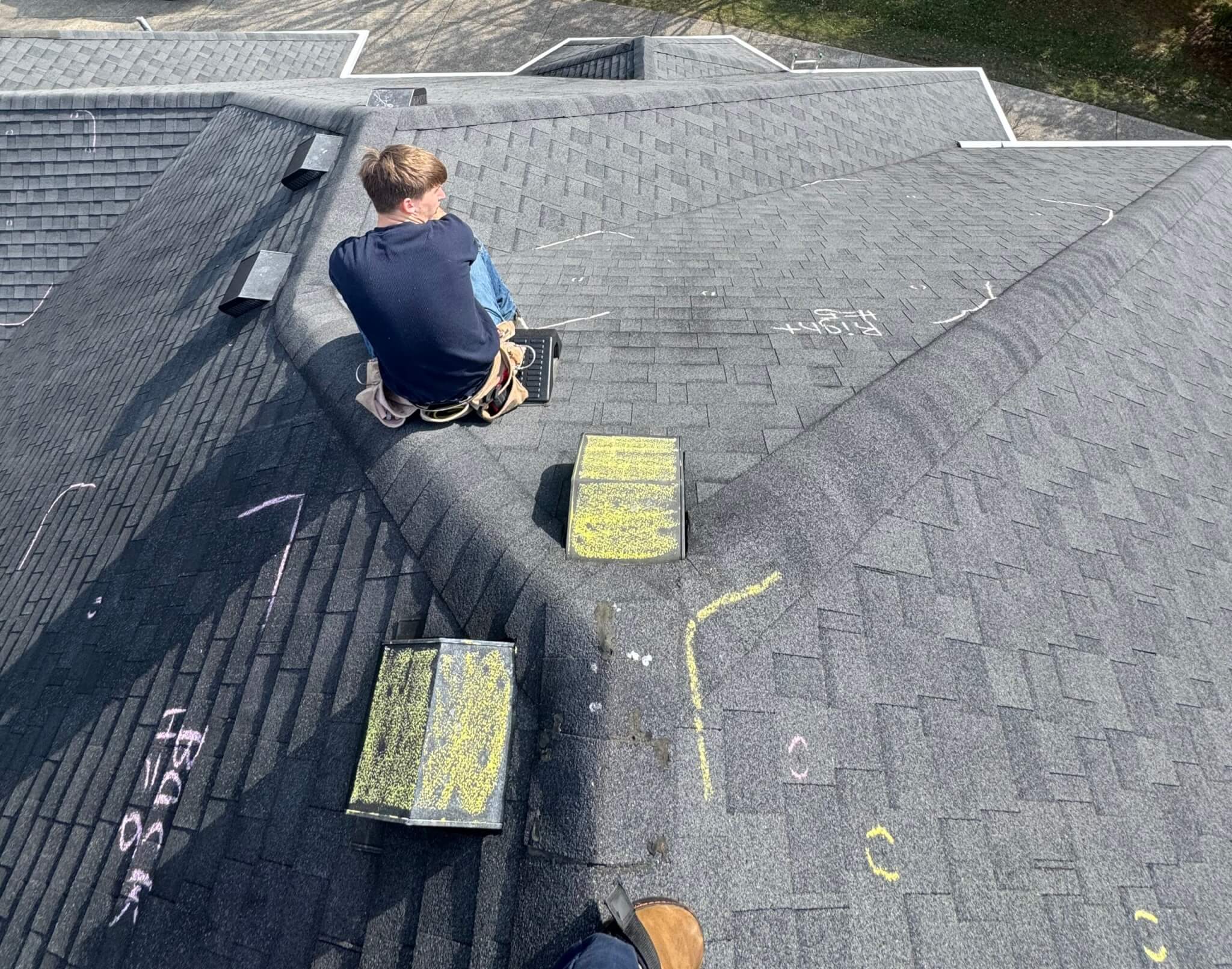 K&P Roofing team member performing a roof inspections, checking slopes for damages and marking the damaged areas.